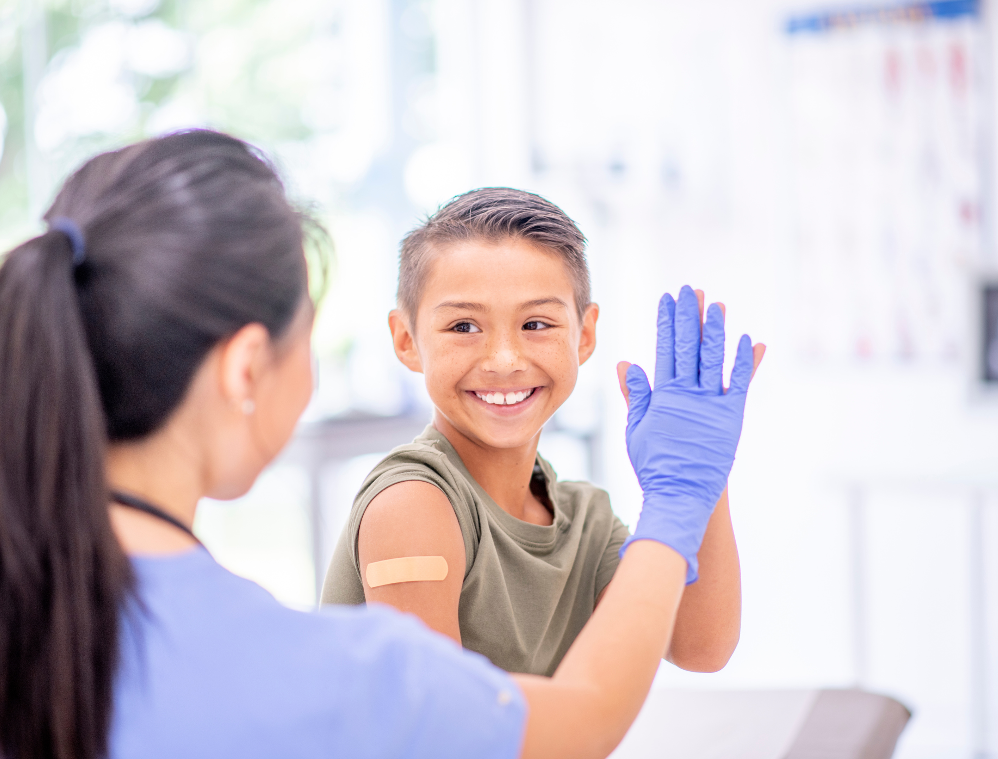 Kid high-fives nurse after receiving an immunization